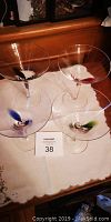 Four martini glasses with colored stems (red, blue, green) on a white cloth.
