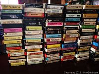 Several stacks of vintage eight track tapes showing various labels with artist names and album titles such as Supertramp, Johnny Cash, The Beatles, and others.