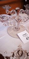 Photo showing the first crystal candle holder with rounded arms and central crystal ball on round base, holding two candles