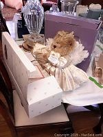 Lydia porcelain doll box on table with crystal lamp and other household items