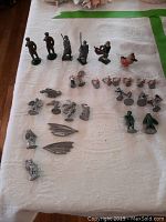 Layout of all lead toy soldiers and fantasy creature figurines on white cloth, showing variety and condition