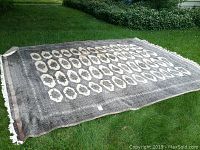Full view of rug laid out on grass showing overall pattern and size