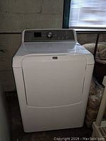 Front view of closed Maytag Bravos XL dryer in white with control panel on top.