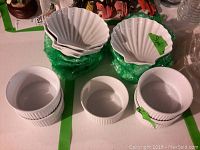 12 Dansk shell plates stacked, 5 custard cups and 4 tart cups grouped on table