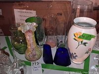 Overview of lot showing eleven vases of varying sizes and colors including Tiffany-style floral vase and cobalt blue pair.