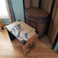 Photo showing wood cabinet with rounded front and fabric-covered accent table with decorative motifs.