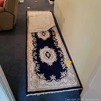 Blue floral runner rug stretched out on floor showing full length and decorative border.