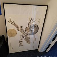 Framed abstract wall art depicting a figure and geometric shapes in neutral shades.