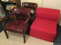 Pair of vinyl chairs with wood frames and red plush folding chair shown together