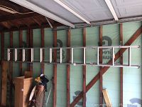 Full length photo of the aluminum extension ladder leaned horizontally against a wall, showing its approximate 12ft length and dual section design.