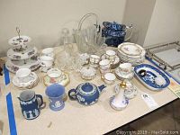 Wide view of entire collection on table showing variety of porcelain, glassware, and tea serving items.