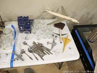 Full table view showing Boeing 720B desk model on stand, additional airplane models, utensils, clear glassware, and blue boxed playing cards.
