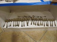 31 sterling silver spoons in a row display, both standard and demitasse sizes