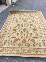 Full view of the Sphinx area rug showing the overall floral and vine design with border.