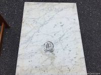 Top view of a white rectangular marble table top with natural gray veining and visible wear marks.