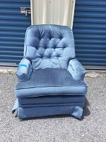 Front full view of the blue upholstered chair showing overall condition and design with tufted backrest, padded arms and skirted base.
