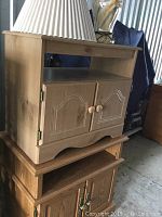 Wood side table with storage cabinet and open shelf showing wood finish, scratches, and nicks.