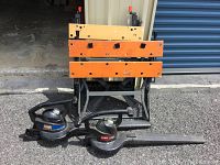 Photo of two saw tables stacked and two Toro leaf blowers placed in front on the ground.