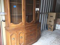 Full front view of vintage Century brand china cabinet showing glass doors above and wooden drawers and doors below, medium brown wood with decorative molding and brass handles. Scratches and nicks visible.