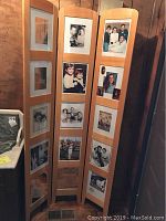 Full view of the wooden photo room divider with various family photos in the frames