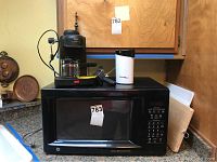 Photo showing GE Carousel microwave on countertop with Proctor Silex coffee grinder and Krups espresso maker on top.