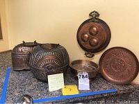 A group shot on counter showing various Turkish brass and copper items including large brass box, decorative trays and smaller boxes.