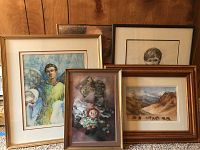 Four framed artworks are shown together against a wood-paneled background on carpeted floor. Includes two portraits, one still life, and one landscape.