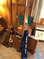 Photo of Stanrite 450 metal easel in blue carrying bag and wooden easels on floor