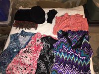 Photo showing four dresses in various colors and patterns laid out with matching fashion accessories including a wool hat, wool scarf, polyester scarf, black gloves, and a coral top.