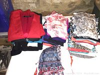 Overview of folded women's summer clothing including tops, sweaters, skirts and dresses