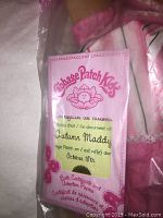 Close up photo of Cabbage Patch Kids birth certificate for doll named Autumn Maddy, date October 18th, in pink card frame.