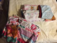 Two twin sheet sets folded and displayed on a bed with Disney Princess and Paw Patrol themes.