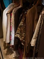 Photo of eight women's jackets hanging on a rack in assorted fabrics and colors including animal print, solid beige and patterns