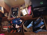 Four boxes containing assorted women's shoes, boots, purses, and belts in various colors and styles, mostly size 8-9 footwear.