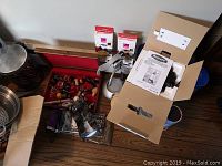 Wine chiller, assorted wine stoppers, coasters and related accessories arranged together on surface showing item variety.