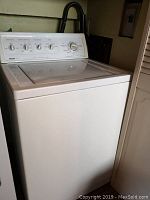 Front and side view of Kenmore 80 series white top-loading washing machine showing overall unit and lid.