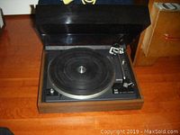 Open top view showing the Dual 502 record player with wood grain base, rubber platter mat and tonearm on the right side.