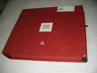 Red textured box with label 'CANADA IN WINTER 1991', showing corner damage and surface stains