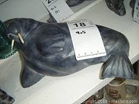 Image showing the front and side profile of the walrus sculpture highlighting the polished soapstone surface and wooden tusks.