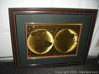Front view of the framed foil world map with dark matting and wooden frame showing the double hemisphere gold foil map.
