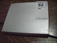 White textured outer box with auction label on top.