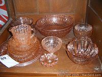 Overview of the complete vintage pink depression glass collection with all items including bowls, creamer, plates, and nut dish.
