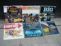 Photo of six vintage hot rod and surf music vinyl LP records with colorful album covers showing identified artists and titles.