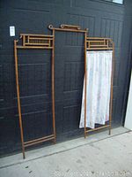 Full view of the three-section old solid wood room divider showing two empty wooden frames and one with cloth panel featuring Kermit and Miss Piggy.