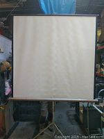 Front view of the Dalite vintage projection screen fully extended showing the projection surface and casing support end caps.