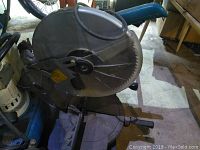 Side view of Makita chop saw showing blade, handle, and base with angle adjustment.