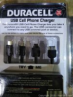 Close-up of Duracell USB cell phone charger packaging showing four different connectors and try-me feature.