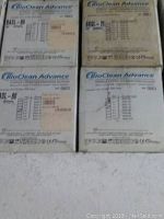 Photo of four sealed boxes of BioClean Advance latex gloves, product codes BASL-75 and BASL-80, showing size and quantity labels.