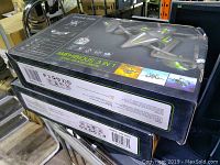 Two stacked Riviera Amphibious 3in1 drones in original boxes, black with green highlights, showing product branding and features.