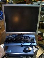 Front view of HP desktop PC with keyboard, mouse, and Lenovo monitor